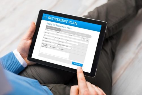 Stock photo, over the shoulder photo of a person using a tablet, filling out a retirement plan application