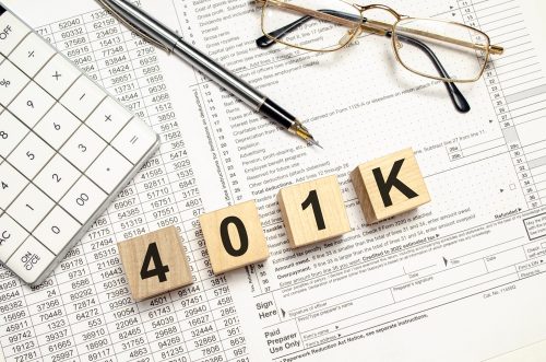 Stock photo, financial statements, a calculator, a pen, glasses, and letter blocks spelling out "401k"